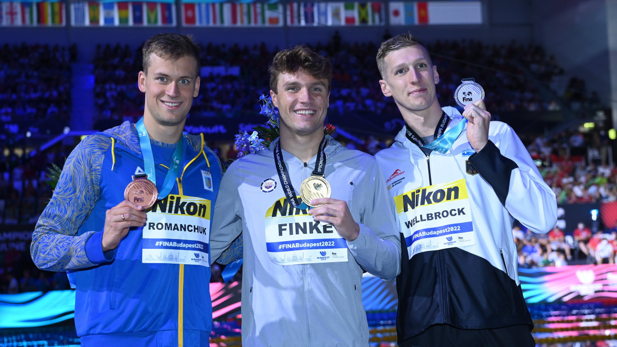 A győztes amerikai Bobby Finke (k), a második helyezett német Florian Wellbrock (j) és a harmadik helyezett ukrán Mihajlo Romancsuk (b) a férfi 800 méteres gyorsúszás eredményhirdetésén a vizes világbajnokságon a Duna Arénában 2022. június 21-én.