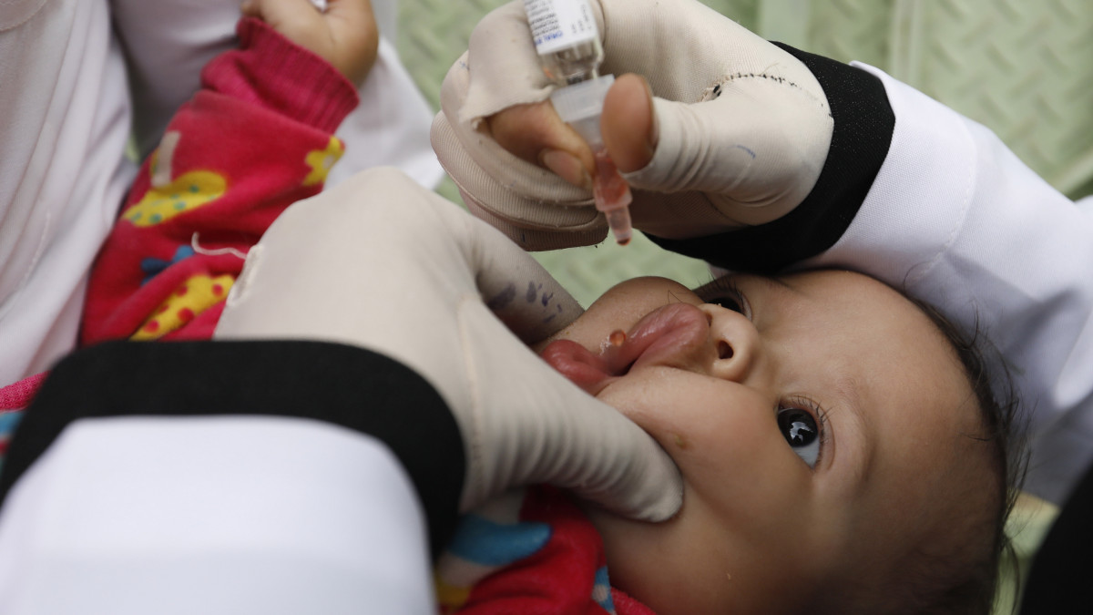 Gyermekbénulás elleni szert cseppentenek egy gyerek szájába a jemeni fővárosban, Szanaában 2020. november 29-én. A jemeni hatóságok egy egészségügyi program keretében több mint öt millió, öt éven aluli kisgyereket kívánnak beoltani.