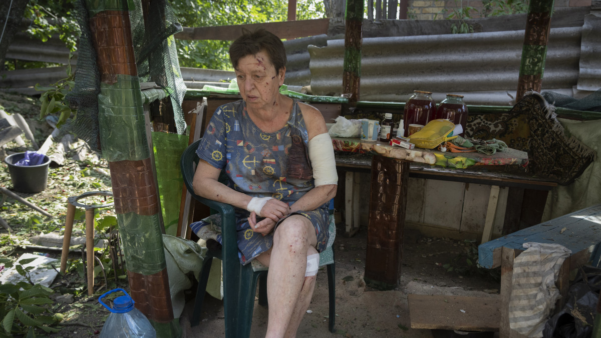 Orosz tüzérségi támadásban megsebesült nő ül megrongált otthonának kertjében a kelet-ukrajnai Bahmutban 2022. június 26-án. Az ukrajnai háború kezdete óta mintegy 5,7 millió ukrán állampolgár menekült az Európai Unió területére, és több mint 7 millió ember kényszerült otthona elhagyására Ukrajnán belül.