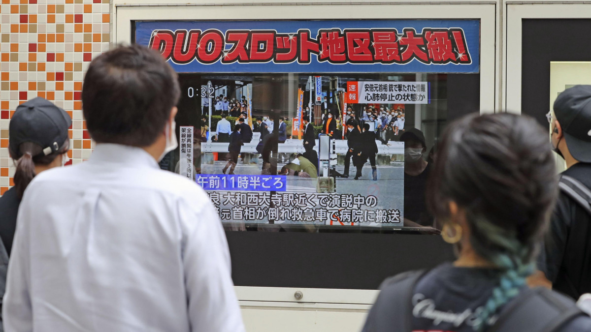 Abe Sindzó korábbi japán miniszterelnökről szóló televíziós híradást néznek járókelők Tokióban, miután Abe ellen merényletet követtek el egy választási kampányeseményen a közép-japáni Narában 2022. július 8-án. Abe a lövéstől eszméletét vesztette, az elkövetőt elfogták.