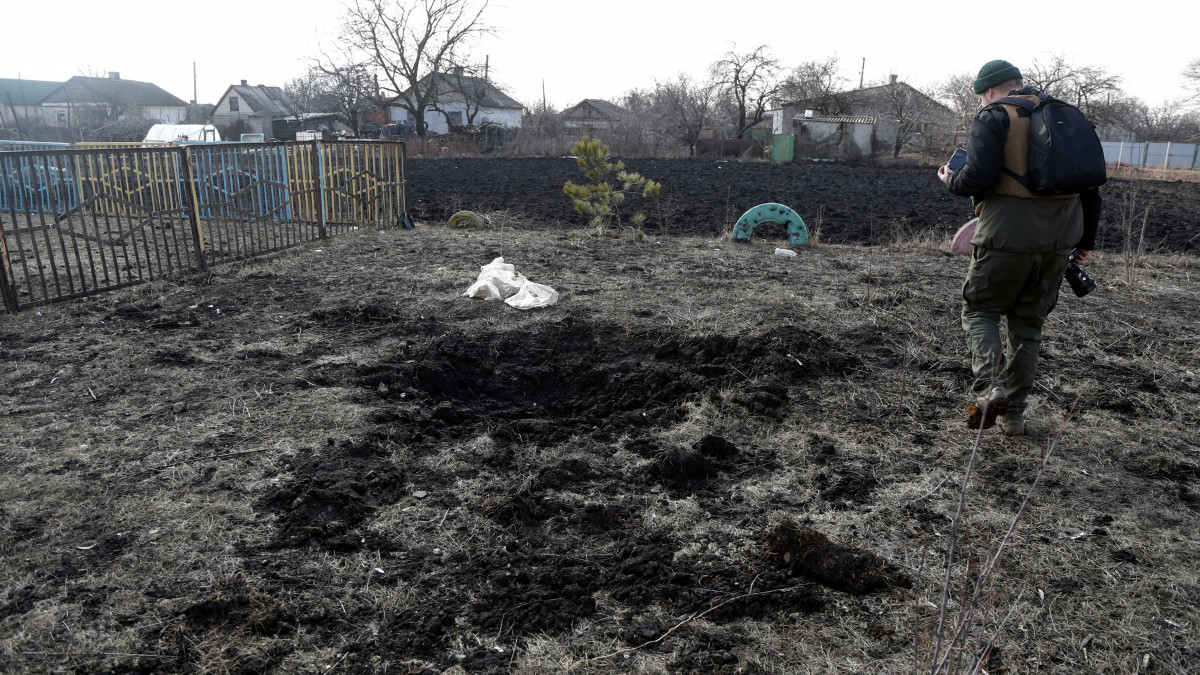 Tüzérségi lövedék becsapódása nyomán keletkezett krátert néz egy férfi az oroszbarát szeparatisták ellenőrzése alatt álló délkelet-ukrajnai Luhanszk közelében lévő Vibrovka faluban 2022. február 23-án. Vlagyimir Putyin orosz államfő február 21-én elismerte a délkelet-ukrajnai oroszbarát szakadár területek függetlenségét, és együttműködési megállapodást írt alá a Kremlben Gyenyisz Pusilinnal, a Donyecki Népköztársaság és Leonyid Paszecsnyikkal, a Luhanszki Népköztársaság vezetőjével. Békefenntartókat küldött a szakadár területekre, amelyre válaszul az Európai Unió, az Egyesült Államok és más nyugati országok újabb szankciókat léptettek életbe orosz bankokkal és személyekkel szemben.