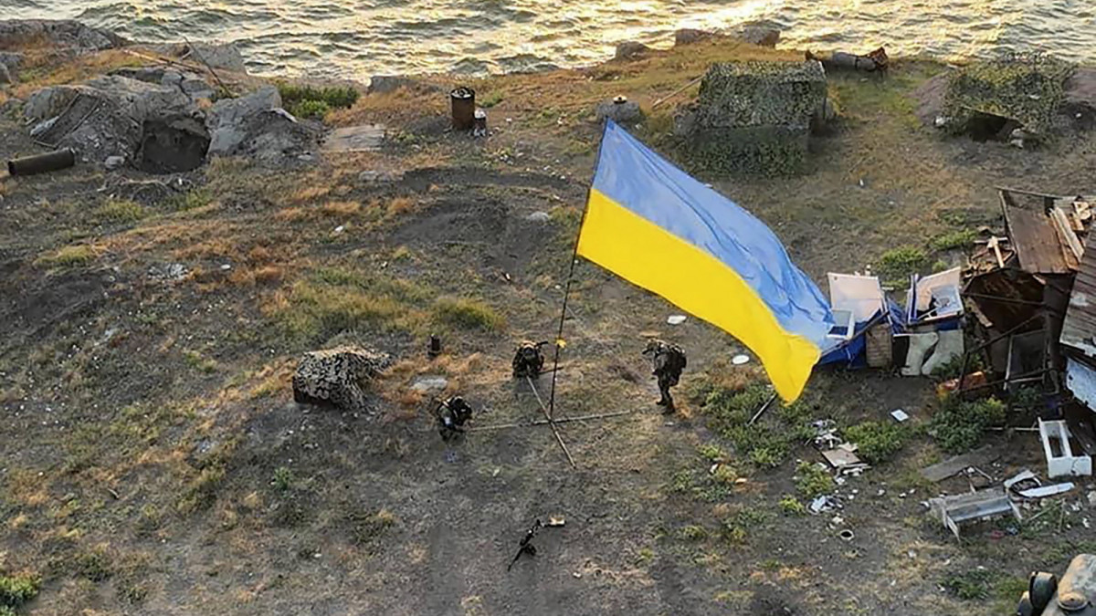 Az ukrán védelmi minisztérium által közreadott képen ukrán katonák kitűzik az ukrán zászlót a fekete-tengeri Kígyó-szigeten 2022. július 7-én.  Az orosz csapatok június végén hagyták el a Kígyó-szigetet.