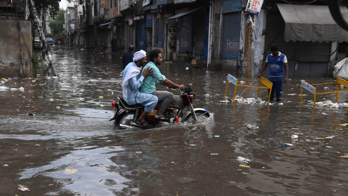 Motoros gázol egy árvízben álló utcán a pakisztáni Lahorban 2021. szeptember 21-én. Az elmúlt 24 órában heves monszuneső bénította meg a közlekedést a városban.