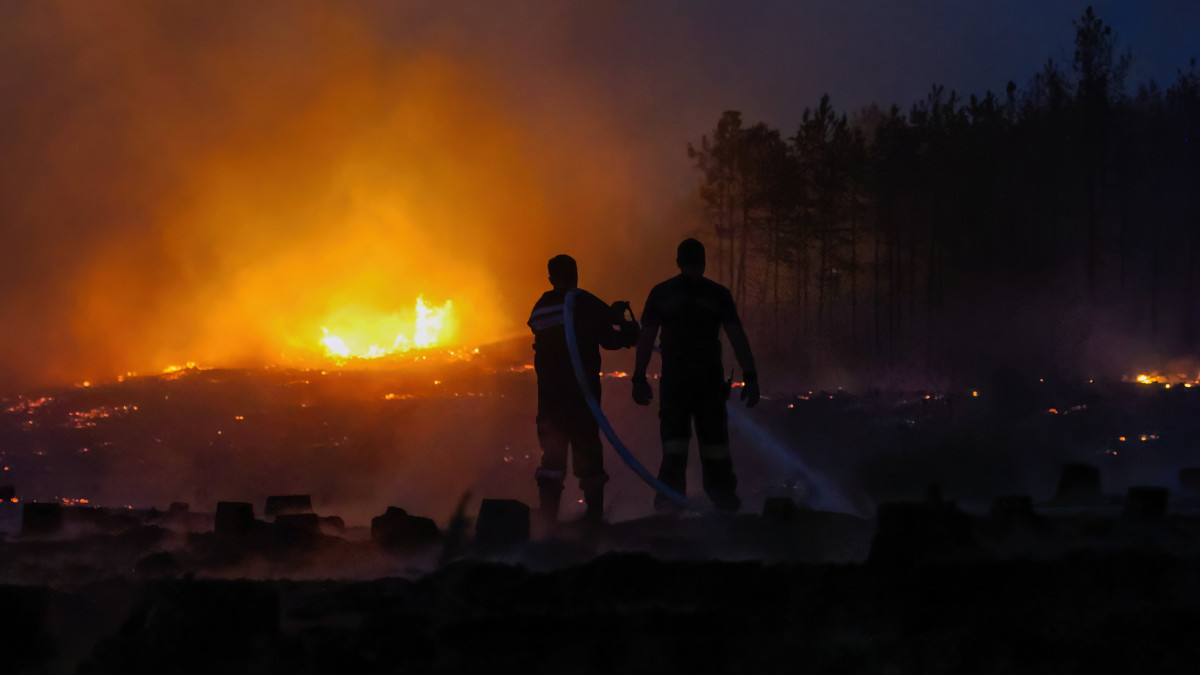 Tűzoltók oltják 2022. július 13-án az Izsák és Soltszentimre közötti erdőben délután keletkezett tüzet. Mintegy ötven hektáron égett részben az aljnövényzet, részben a fák koronája. Személyi sérülésről nem érkezett információ.