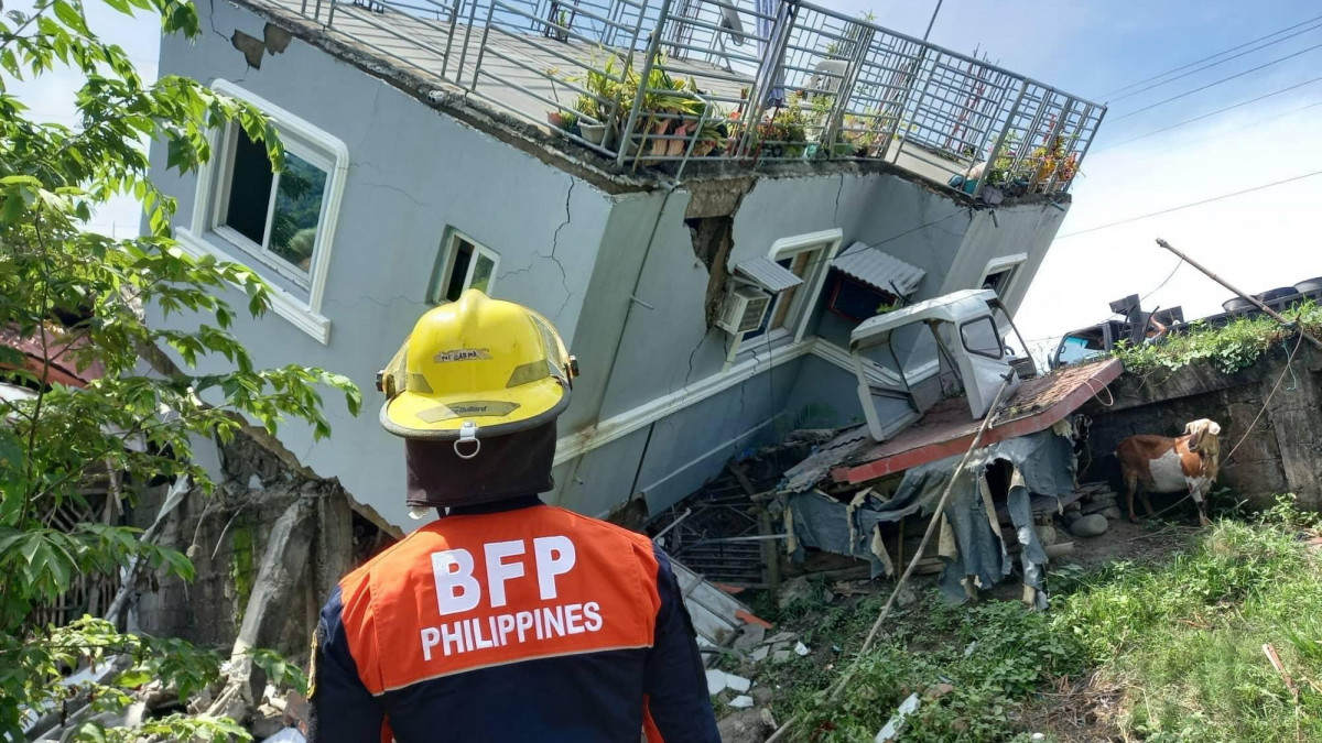 A Fülöp-szigeteki Tűzvédelmi Hivatal által közreadott képen összedőlt ház az Ilocos Sur tartományban fekvő Santiagóban 2022. július 27-én, miután 7,3-es erősségű földrengés volt a Fülöp-szigetek északi részén. Egyelőre egy sérültről tudni.
