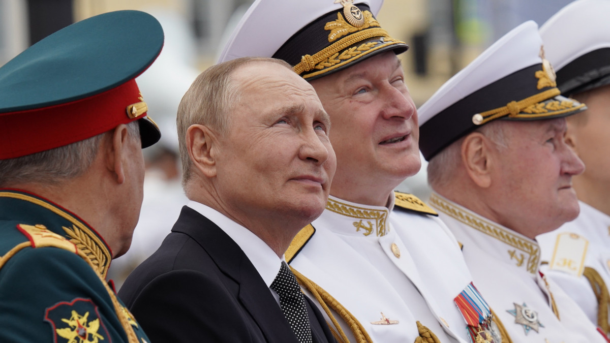 Vlagyimir Putyin orosz elnök (b2), Szergej Sojgu védelmi miniszter (b) és Nyikolaj Jevmenov, az orosz haditengerészet főparancsnoka (b3) az orosz haditengerészet napjának alkalmából tartott szentpétervári flottadíszszemlén 2022. július 31-én.