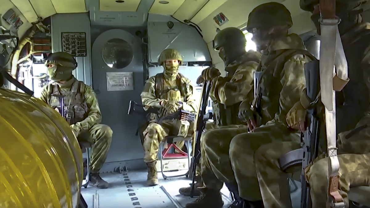 Az orosz védelmi minisztérium által 2022. július 30-án közreadott képen orosz katonák egy harci helikopteren utaznak bevetésre egy meg nem nevezett területen.