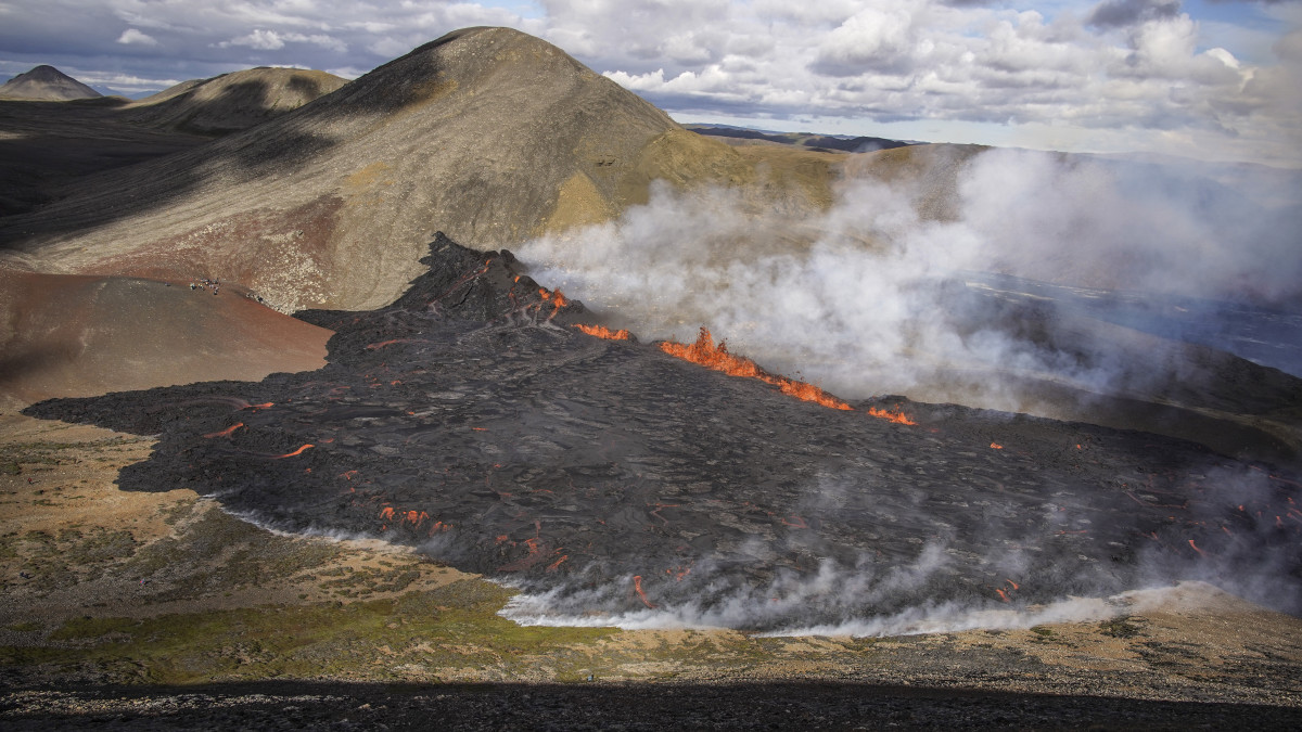 Láva ömlik és füst gomolyog a Fagradalsfjall tűzhányóból 2022. augusztus 3-án este, miután kitört a vulkán az izlandi fővárostól, Reykjaviktól 32 kilométerre délnyugatra, közel a Keflavik repülőtérhez. A tűzhányó legutóbbi kitörése nyolc hónappal korábban fejeződött be.