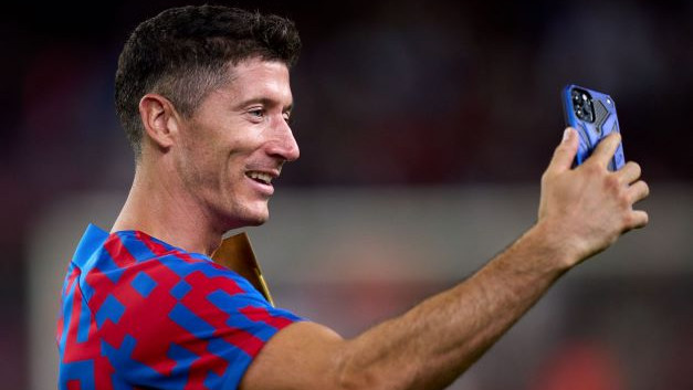 Robert Lewandowski of FC Barcelona records a video on a mobile phone for the FC Barcelona social media channels following the Joan Gamper Trophy match between FC Barcelona and Pumas UNAM at Spotify Camp Nou on August 07, 2022 in Barcelona, Spain. (