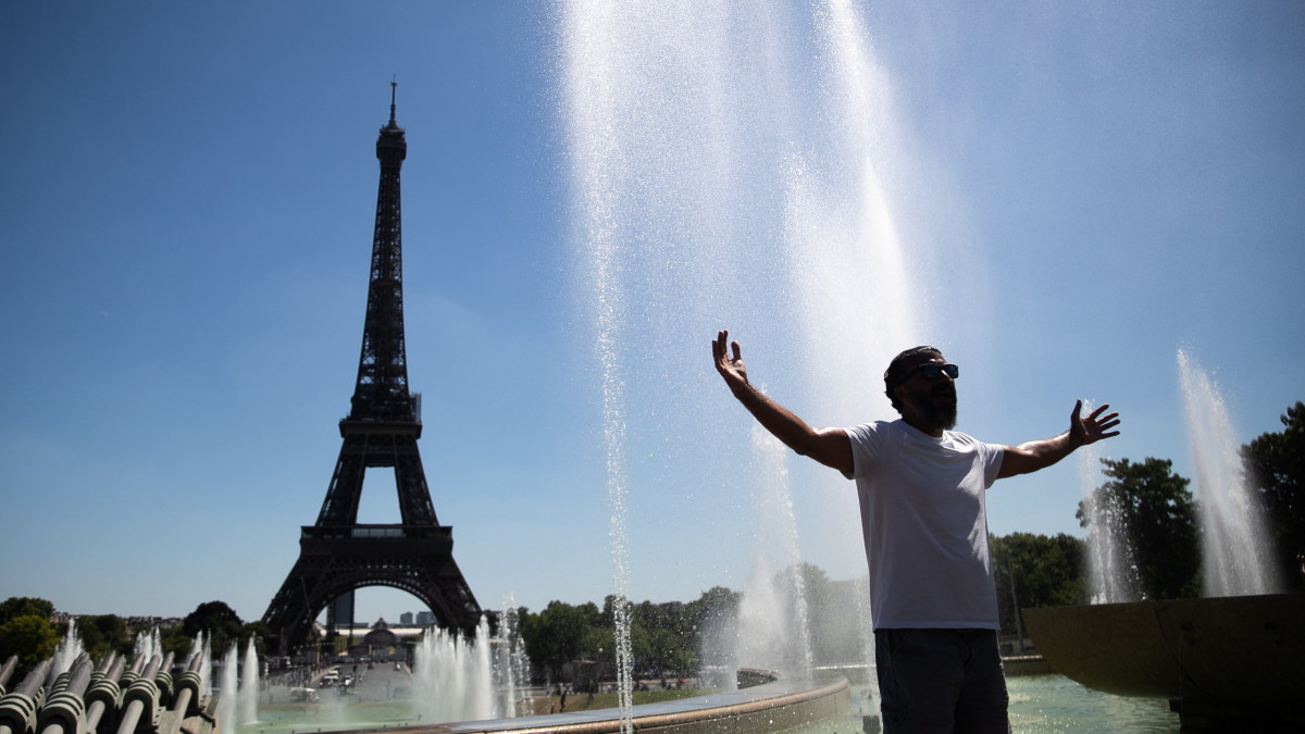 Egy férfi hűsöl a párizsi Trocadéro tér szökőkútjainak medencéjében 2022. augusztus 3-án. A francia fővárosban 36 Celsius-fokos hőség tombol ezen a napon. A háttérben az Eiffel-torony.
