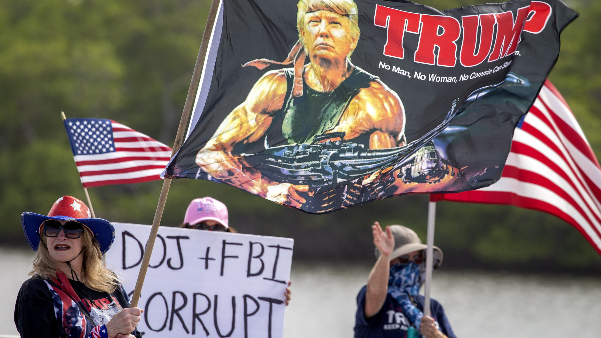 Tüntetők tiltakoznak a hatósági intézkedés ellen Donald Trump volt amerikai elnök floridai rezidenciájának bejárata előtt Palm Beachben 2022. augusztus 9-én. Előző nap az épületegyüttesben a Szövetségi Nyomozó Iroda (FBI) nyomozói bejelentés nélküli házkutatást tartottak.