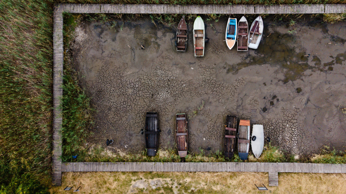 Drónfelvételen csónakok a Velencei-tó medrében, Pákozd közelében 2022. július 28-án. A tartós hőség miatt a tó vízállása alig egy centiméterrel magasabb a valaha mért legalacsonyabb szintnél, 63 centiméternél.