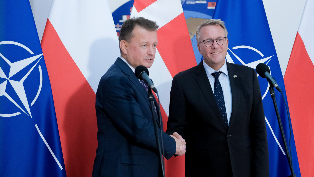 Mariusz Blaszczak lengyel védelmi miniszter (b) és dán hivatali partnere, Morten Bodskov kezet fog a megbeszélésüket követő sajtóértekezleten Varsóban 2022. szeptember 12-én.
