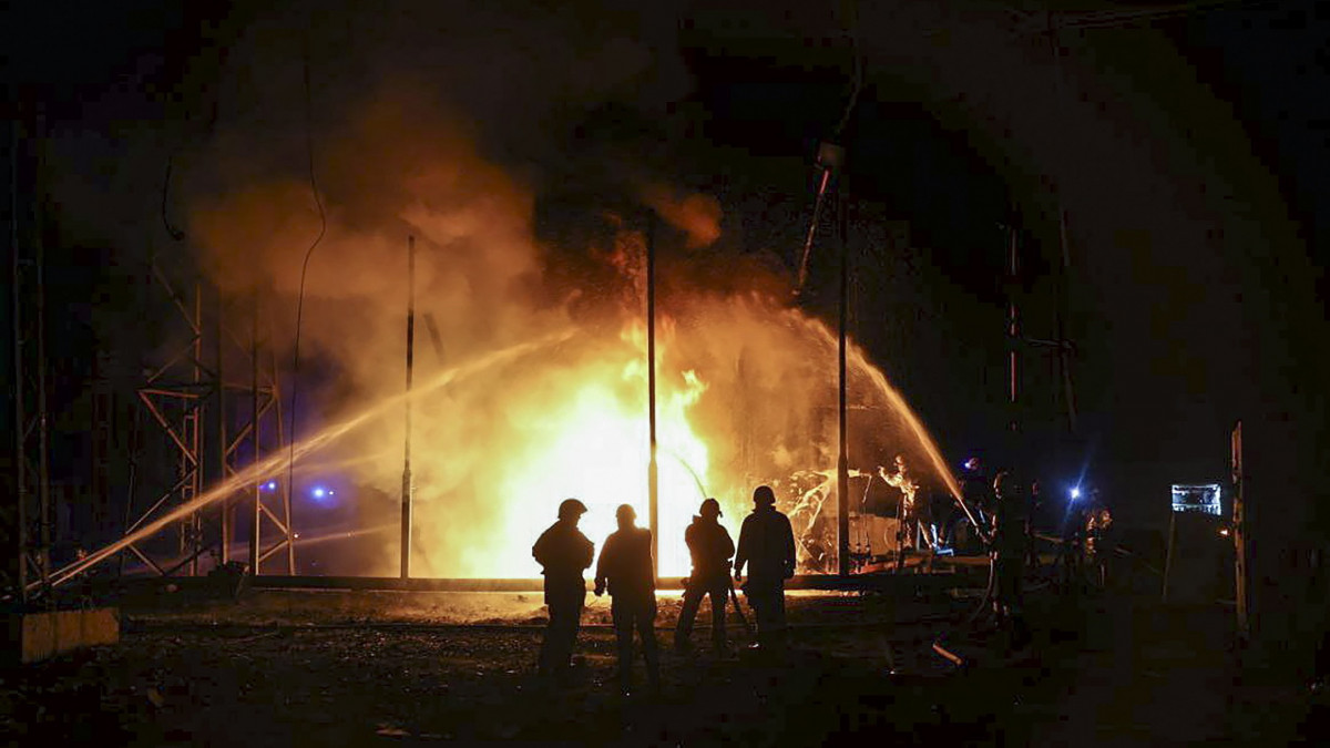 Tűzoltók küzdenek a lángok megfékezésén egy orosz tüzérségi támadásban megrongálódott áramszolgáltató létesítménynél a kelet-ukrajnai Harkivban 2022. szeptember 11-én.