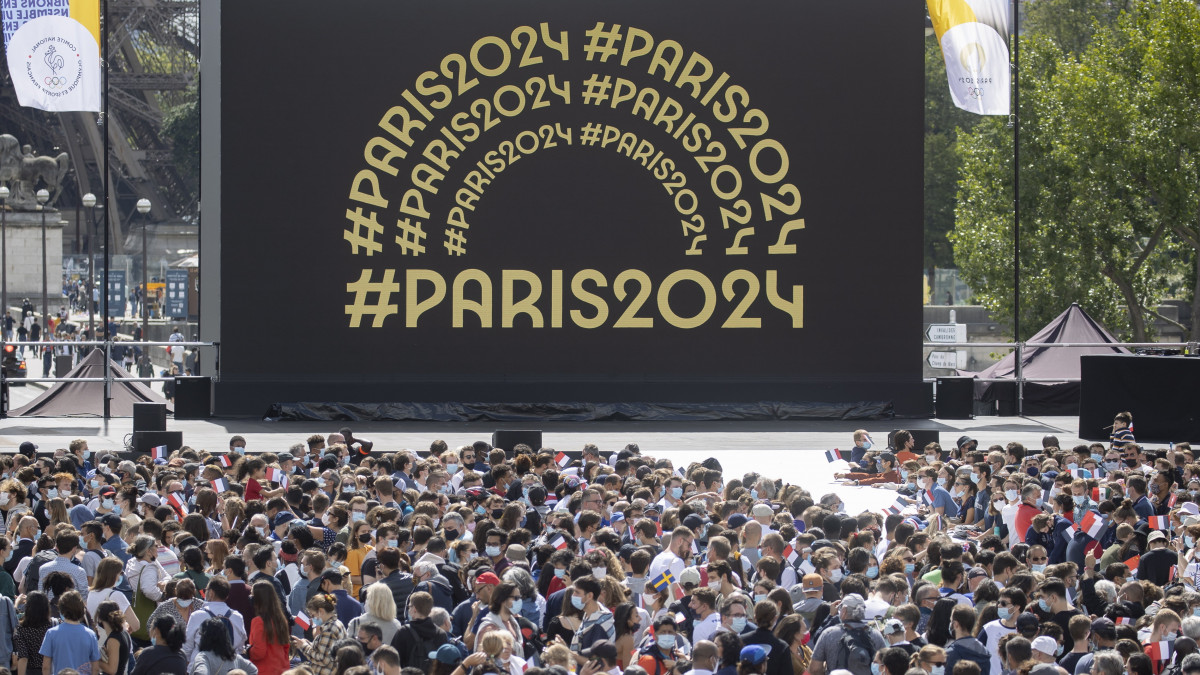 Az olimpiai szurkolói övezet látogatói a párizsi Eiffel-torony előtti Trocadero téren 2021. augusztus 8-án, a világméretű koronavírus-járvány miatt 2021-re halasztott 2020-as tokiói nyári olimpia utolsó napján. A Trocadero téren megünneplik, hogy a 2024-es nyári játékokat rendező Párizs átvette az olimpiai zászlót a japán fővárostól.
