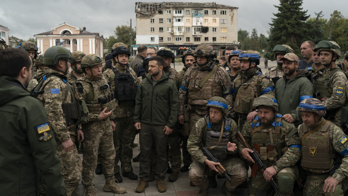 Volodimir Zelenszkij ukrán elnök (k) katonákkal beszélget az ukrán hadsereg által visszafoglalt Izjumban rendezett ünnepélyes zászlófelvonás után 2022. szeptember 14-én.