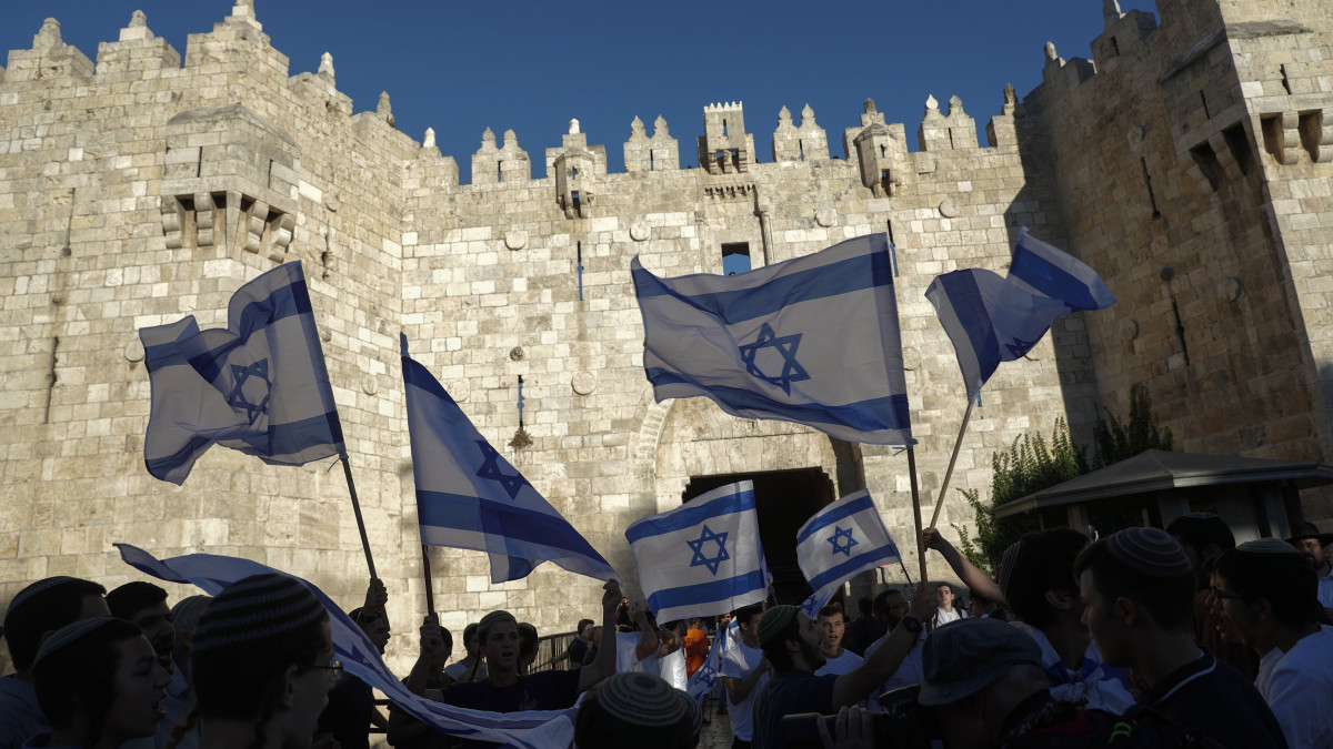 Izraeli nacionalisták a Damaszkuszi kapunál a Jeruzsálem óvárosában tartott zászlós felvonulásukon 2021. június 15-én. Mivel a Benjámin Netanjahu volt konzervatív miniszterelnök hívei által szervezett felvonulás a muszlimok lakta negyedeket is érinti, a palesztinok provokációnak tekintik.