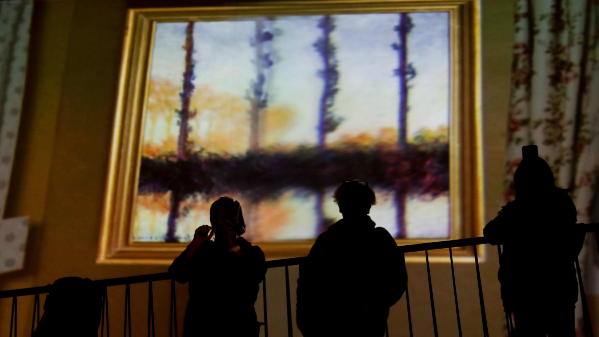 Látogatók nézik a falra vetített festményeket Claude Monet francia impresszionista festőművész alkotásainak virtuális kiállításán a brüsszeli Horta Galériában. A különleges élményt és látványt multimédiás eszközök biztosítják.