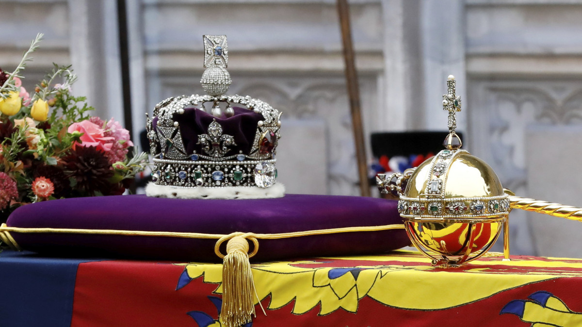 Koronázási ékszerek és a kétezer gyémánttal ékesített birodalmi állami korona (k) II. Erzsébet néhai brit uralkodó ágyútalpra helyezett koporsóján 2022. szeptember 19-én. II. Erzsébet hosszas betegeskedés után, életének 97., uralkodásának 71. évében, szeptember 8-án hunyt el Balmoralban, a királyi család nyári skóciai rezidenciáján. A királynőt a windsori kastély emlékkápolnájában helyezik végső nyugalomra.