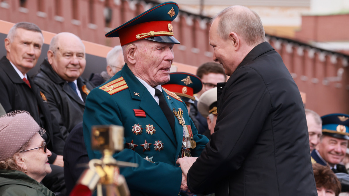 Vlagyimir Putyin orosz elnök (j) háborús veteránokkal találkozik a győzelem napi díszszemlén a moszkvai Vörös téren 2022. május 9-én. Oroszországban május 9-én ünneplik a náci Németország felett a II. világháborúban aratott győzelem 77. évfordulóját.