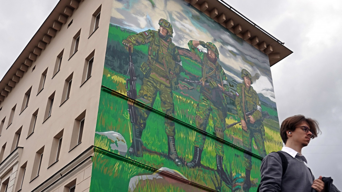 Az Oroszországnak az Ukrajna ellen indított különleges katonai hadműveletét támogató falfestmény előtt megy egy férfi Moszkvában 2022. szeptember 20-án.