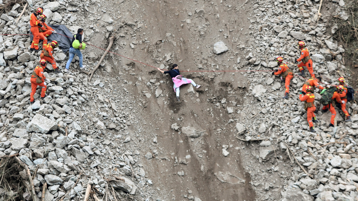 Rescue workers evacuate quake-affected residents at the site of a landslide near Moxi town, following a 6.8-magnitude earthquake in Luding county, Ganzi Tibetan Autonomous Prefecture, Sichuan province, China September 6, 2022. China Daily via REUTERS  ATTENTION EDITORS - THIS IMAGE WAS PROVIDED BY A THIRD PARTY. CHINA OUT.      TPX IMAGES OF THE DAY