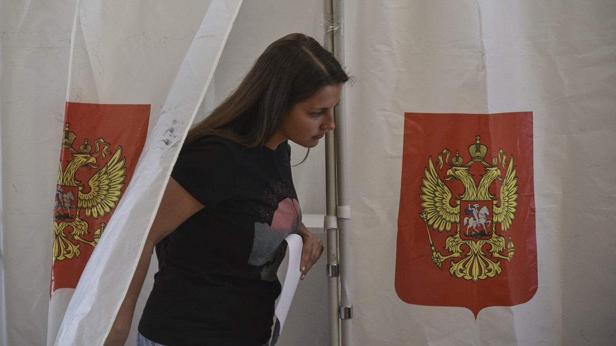 Ukrán nő leadja szavazatát egy orosz címerrel ellátott szavazófülke mellett az Oroszországhoz való csatlakozásról tartott népszavazáson a Krím félszigeti Szevasztopolban 2022. szeptember 23-án. A referendum szeptember 27-ig tart a szakadár Donyecki és Luhanszki Népköztársaság, valamint az orosz megszállás alá került Herszon és Zaporizzsja ukrán megyék hovatartozásáról.