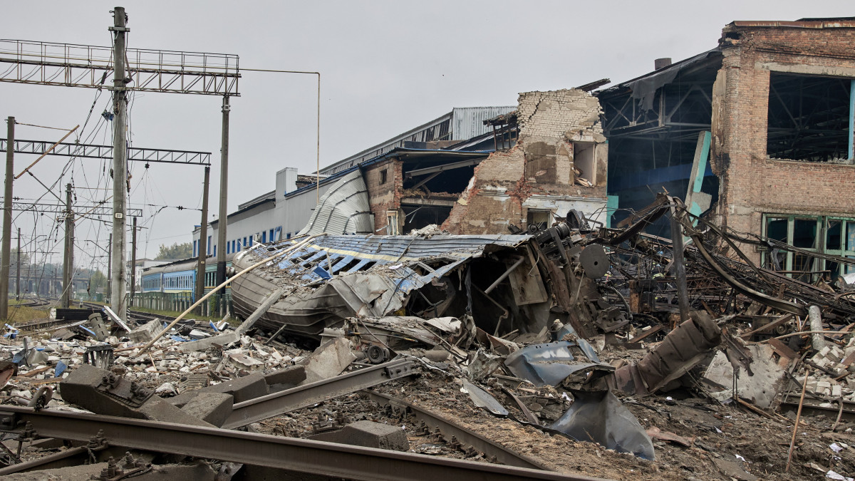 Megsemmisült vasúti sínek és kocsik egy tüzérségi találatot kapott állomásépületnél a kelet-ukrajnai Harkivban 2022. szeptember 28-án.