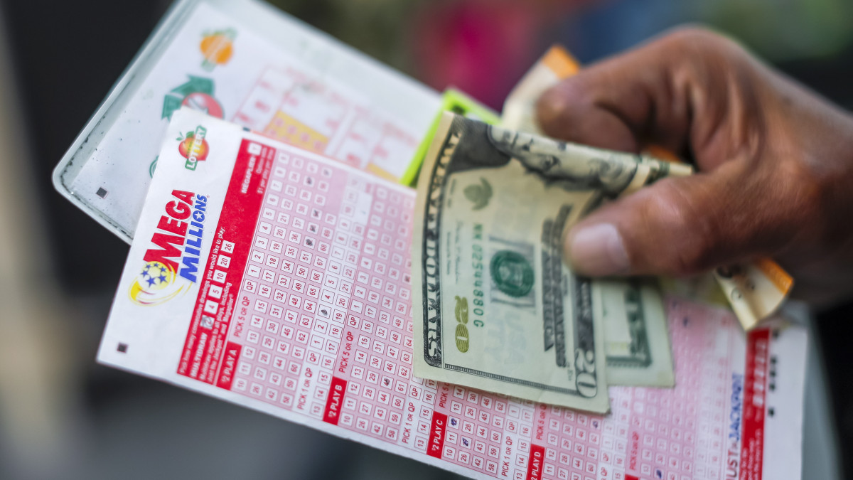 Egy vásárló várakozik a Mega Millions-lottószelvényével a kezében a pénztár előtt a Georgia állambeli Tallapoosa egyik benzinkútján 2021. január 12-én. Az 625 millió dolláros (mintegy 185 milliárd forintos) főnyereményt, amely minden idők negyedik legnagyobb nyereménye a játék történetében, január 12-én este sorsolják ki.