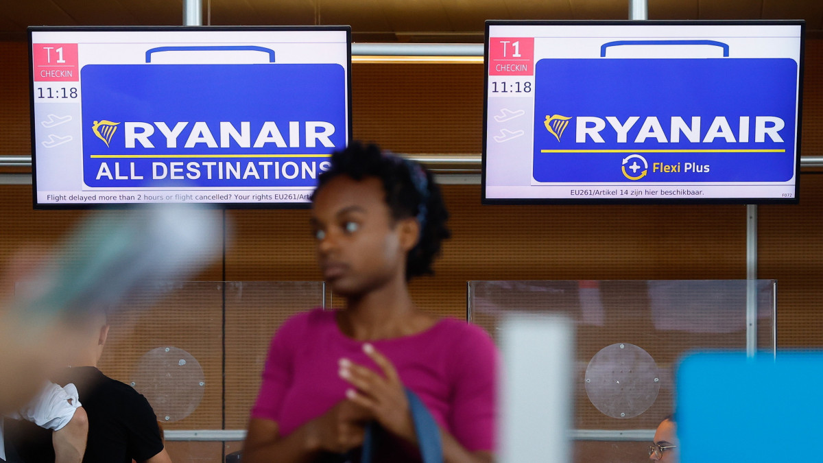 Az utasfelvételnél várakozik egy nő, amint a Ryanair diszkont légitársaság belga pilótái kétnapos bérkövetelő sztrájkot kezdenek a brüsszeli Charleroi nemzetközi repülőtéren 2022. július 23-án. A belga pilóták azt követően döntöttek a munkabeszüntetés mellett, hogy a koronavírus-világjárvány miatti utazáskorlátozás feloldása ellenére sem kapnak ismét teljes fizetést. A légi közlekedést fokozottan érintő pandémia idején a Ryanair belgiumi pilótái az állásuk megtartása fejében húsz százalékos átmeneti bércsökkentésben állapodtak meg az írországi központú légitársasággal. A 48-órás sztrájk mintegy húsz járatot érint a büsszeli Zaventem repülőtéren, és sok tucatnyit a Charleroi-on.