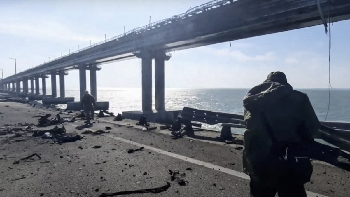 Az orosz vizsgálóbizottság által közreadott videofelvételről készített képen a bizottság munkatársai a Krími híd megsérült részénél 2022. október 8-án, miután az orosz Nemzeti Terrorizmusellenes Bizottság állítása szerint felrobbant egy teherautó az Ukrajnától elcsatolt Krímet és Oroszországot a Fekete- és az Azovi-tenger között összekötő átkelő közúti oldalán. Legalább három ember életét vesztette, az útpálya érintett szakasza beomlott, a vasúti hídon egy tartálykocsikból álló szerelvény kigyulladt.