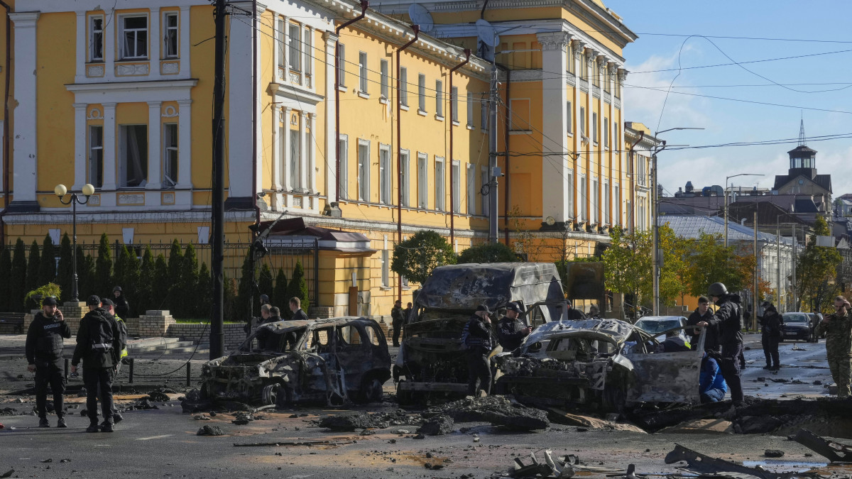 Kiégett autóroncsok mellett rendőrök Kijevben 2022. október 10-én, miután robbanások történtek az ukrán fővárosban.