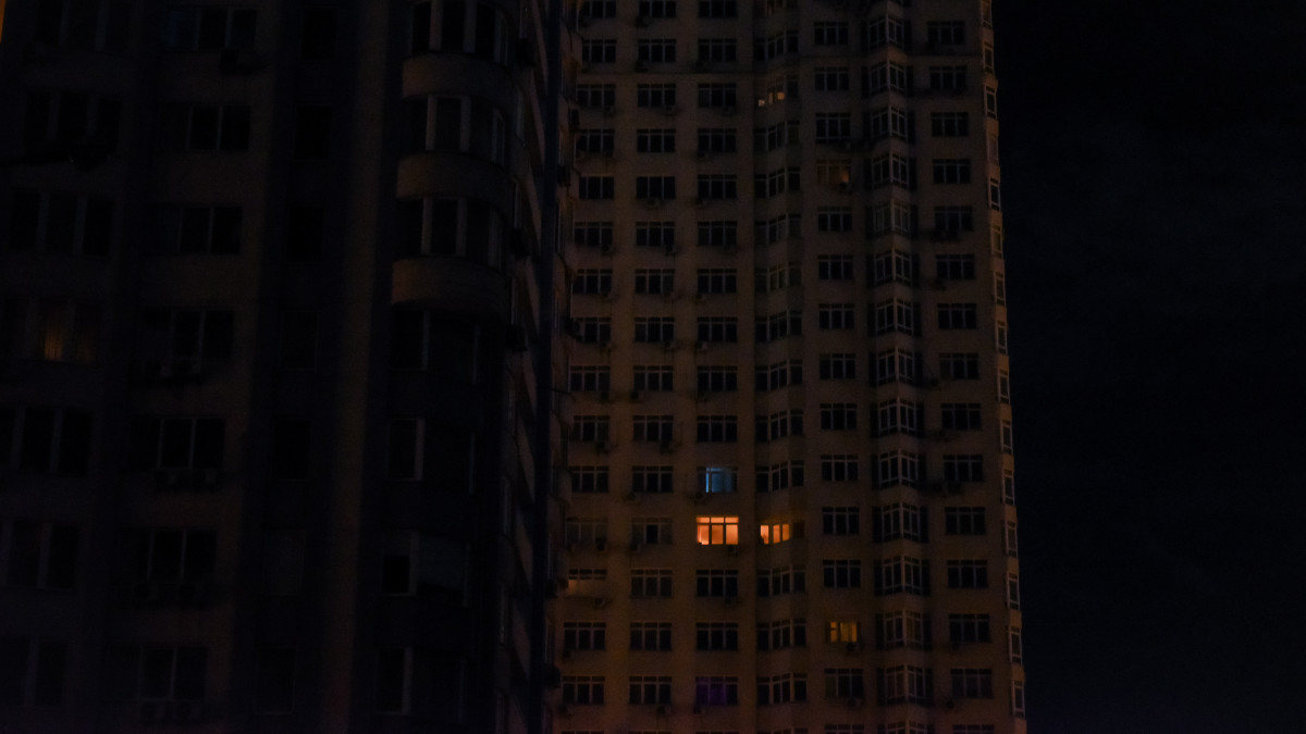 Fény szűrődik ki egy lakótömb néhány ablakából részleges áramkimaradás idején Kijevben 2022. október 22-én. Az orosz erők támadásai megrongálták az ukrán fővárost és egyéb ukrán településeket ellátó energetikai infrastruktúrát.