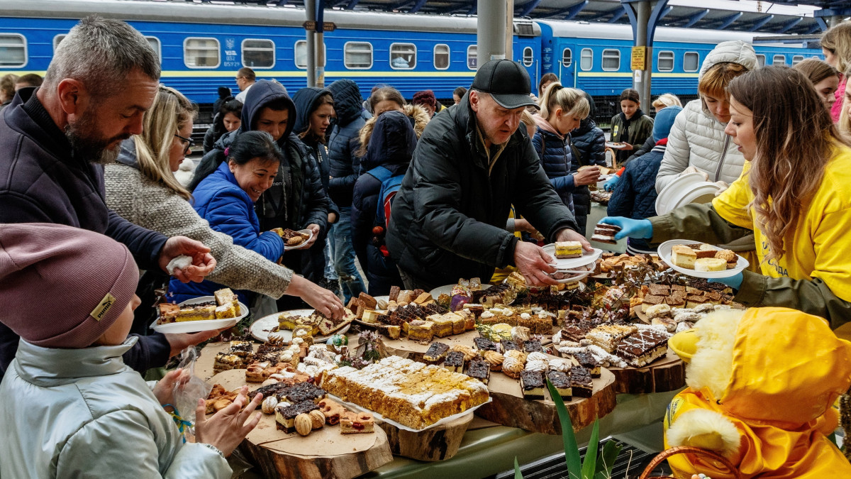 Helyi önkéntes húsvéti ételeket oszt ukrajnai háborús menekülteknek az ungvári vasúti pályaudvar bejáratánál 2022. április 24-én.