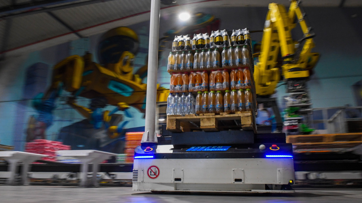 Mesterséges intelligenciával vezérelt robot a Coca-Cola HBC Magyarország dunaharaszti gyártóbázisán 2022. november 8-án. A robot a picking elnevezésű fejlesztéssel a gyártósorról érkező termékek összekészítését, raklapokra helyezését és fóliázását végzi. A fejlesztés több mint 750 millió forintból valósult meg.