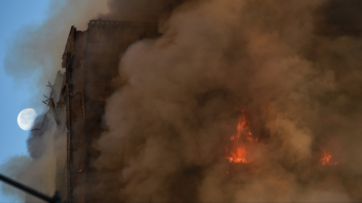 London, 2017. június 14.Sűrű füst gomolyog a lángoló Grenfell Tower épületéből a London nyugati részén lévő North Kensington negyedben 2017. június 14-én. A huszonhét emeletes lakóház lángjainak megfékezéséért mintegy kétszáz tűzoltó küzd. (MTI/EPA/Facundo Arrizabalaga)