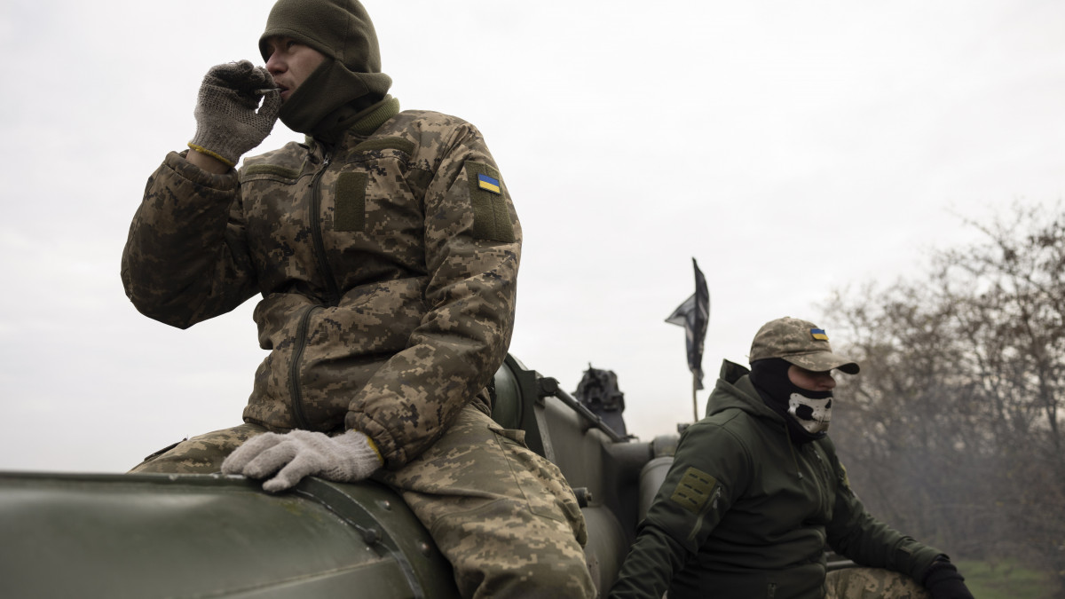 Ukrán katonák egy 203 milliméteres Pion önjáró lövegnél pihennek a dél-ukrajnai Herszon térségében lévő állasukban az Ukrajna elleni orosz háború alatt, 2022. november 9-én.