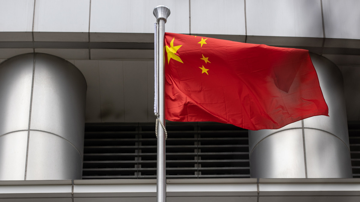 A kínai zászló lobog a kínai központi kormányzat nemzetbiztonsági irodája előtt Hongkongban 2020. július 9-én. Az irodában működő ügynökség feladata, hogy felügyelje a június 30-án hatályba lépett, Hongkongra vonatkozó nemzetbiztonsági törvényt. A jogszabály a jogsértések négy kategóriájaként a szakadár tevékenységet, a felforgatást, a terrorizmust, valamint a nemzetbiztonság veszélyeztetésére külföldi országokkal vagy külső elemekkel való összejátszást sorolja fel.