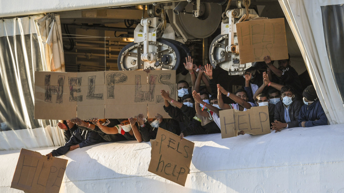Illegális bevándorlók kartonlapokat felmutatva kérnek segítséget az Orvosok Határok Nélkül nem kormányzati szervezet által működtetett Geo Barents norvég hajóról a szicíliai Catania kikötőjében 2022. november 7-én. A hajón 572 migráns tartózkodott, közülük 375, orvosi ellátásra szoruló ember, illetve várandós nő és gyermek kiszállását engedélyezték az olasz hatóságok.