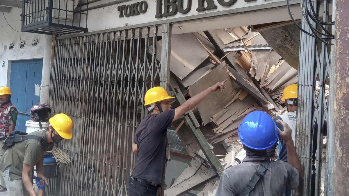 A pusztítás nyomait nézik munkások a Jáva szigetén fekvő Cianjurban 2022. november 21-én, miután 5.6-os erősségű földrengés rázta meg a várost és környékét. A természeti katasztrófa következtében legkevesebb húsz ember életét vesztette és háromszáz megsebesült.