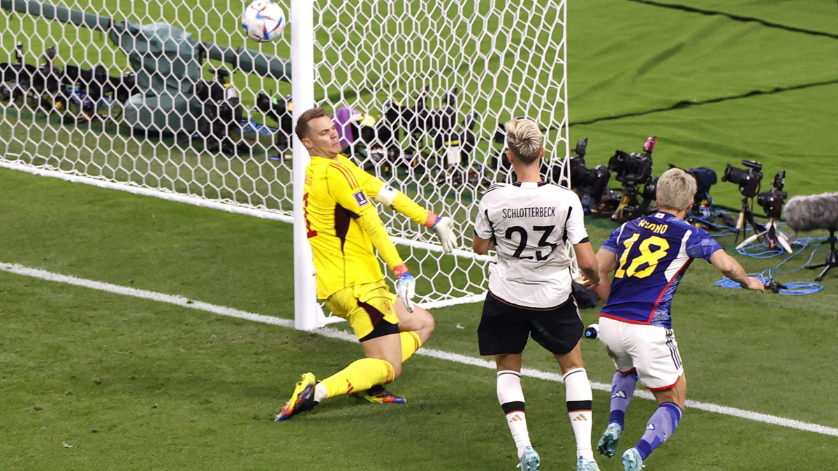 A japán Aszano Takuma (j) berúgja csapata második gólját a német Manuel Neuer kapujába (b) a katari labdarúgó-világbajnokság első fordulójában, a E csoportban játszott Németország-Japán mérkőzésen az ar-rajjáni Halifa Stadionban 2022. november 23-án.