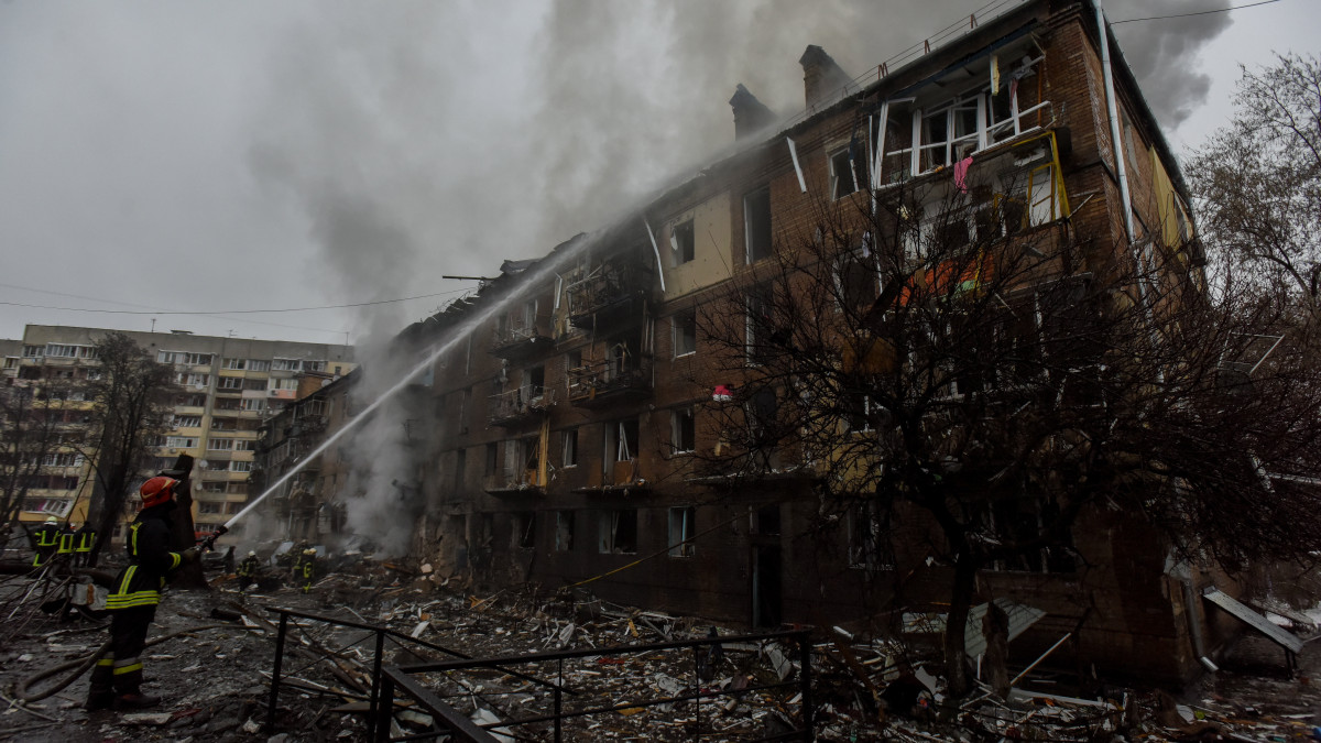 Tűzoltók dolgoznak egy orosz rakétatámadásban megrongálódott lakóépületnél a Kijevtől északra fekvő Vishorodban 2022. november 23-án. Andrij Nyebitov Kijev megyei rendőrfőnök tájékoztatása szerint lakóövezetet és létfontosságú infrastrukturális létesítményeket értek rakétatalálatok a régióban.