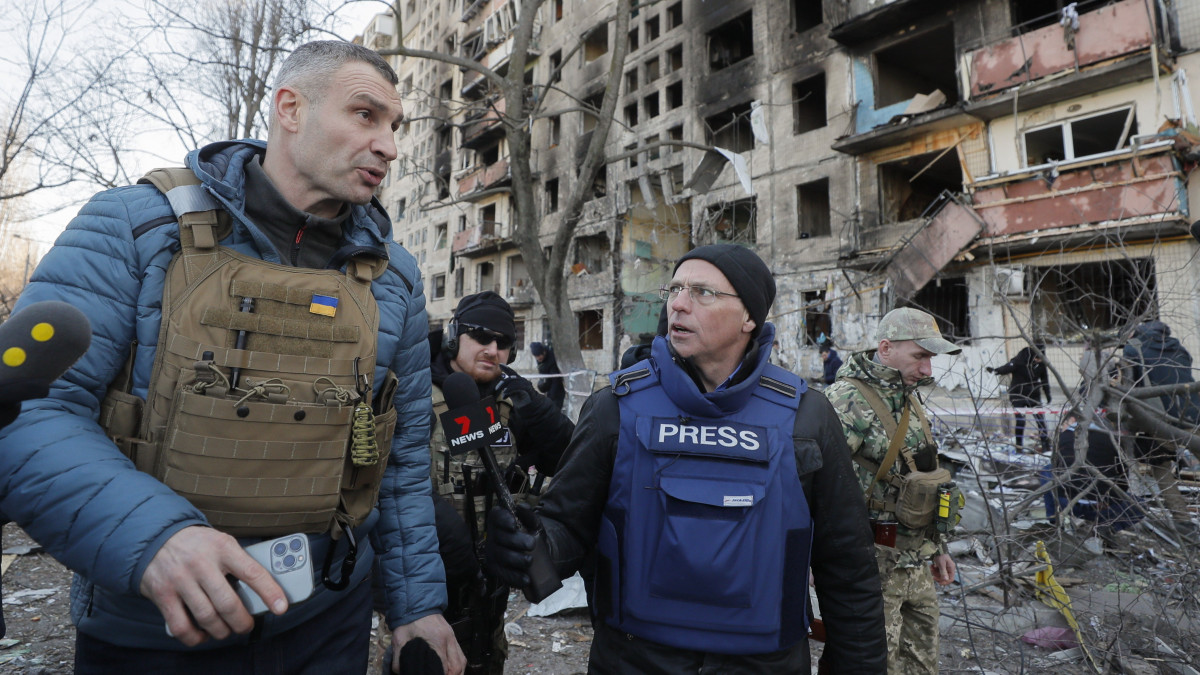 Vitalij Klicsko kijevi polgármester (b) újságírók kérdéseire válaszol egy tüzérségi támadásban megrongálódott lakóépület mellett Kijevben 2022. március 12-én. Vlagyimir Putyin orosz elnök február 24-én rendelte el katonai művelet végrehajtását Ukrajnában.