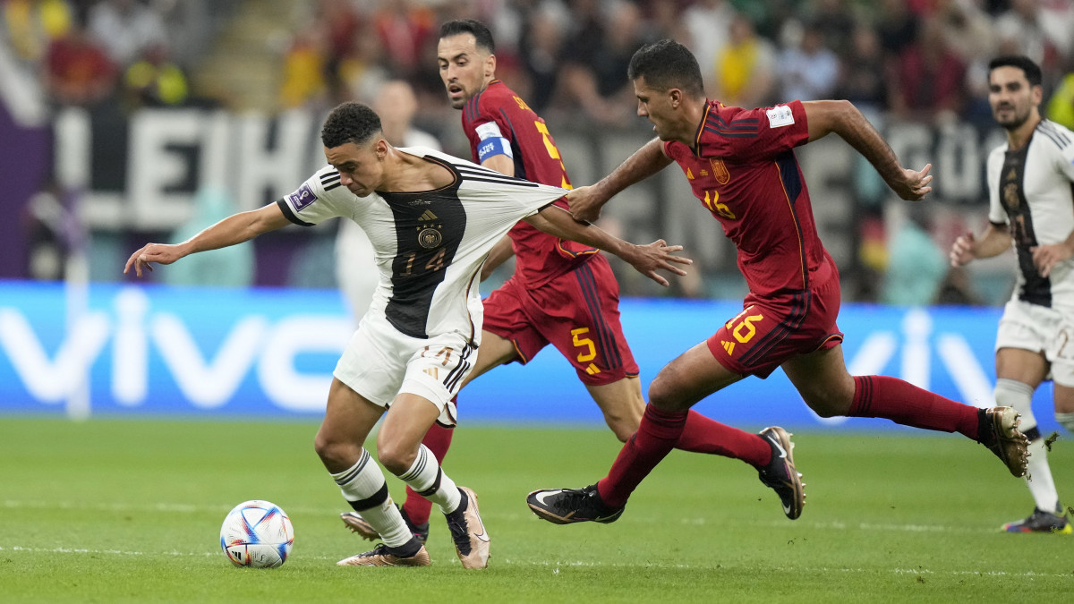 A spanyol Rodri (j) és a német Jamal Musiala (b) a katari labdarúgó-világbajnokság E csoport második fordulójában játszott Spanyolország-Németország mérkőzésen az al-hori al-Bajt Stadionban 2022. november 27-én.
