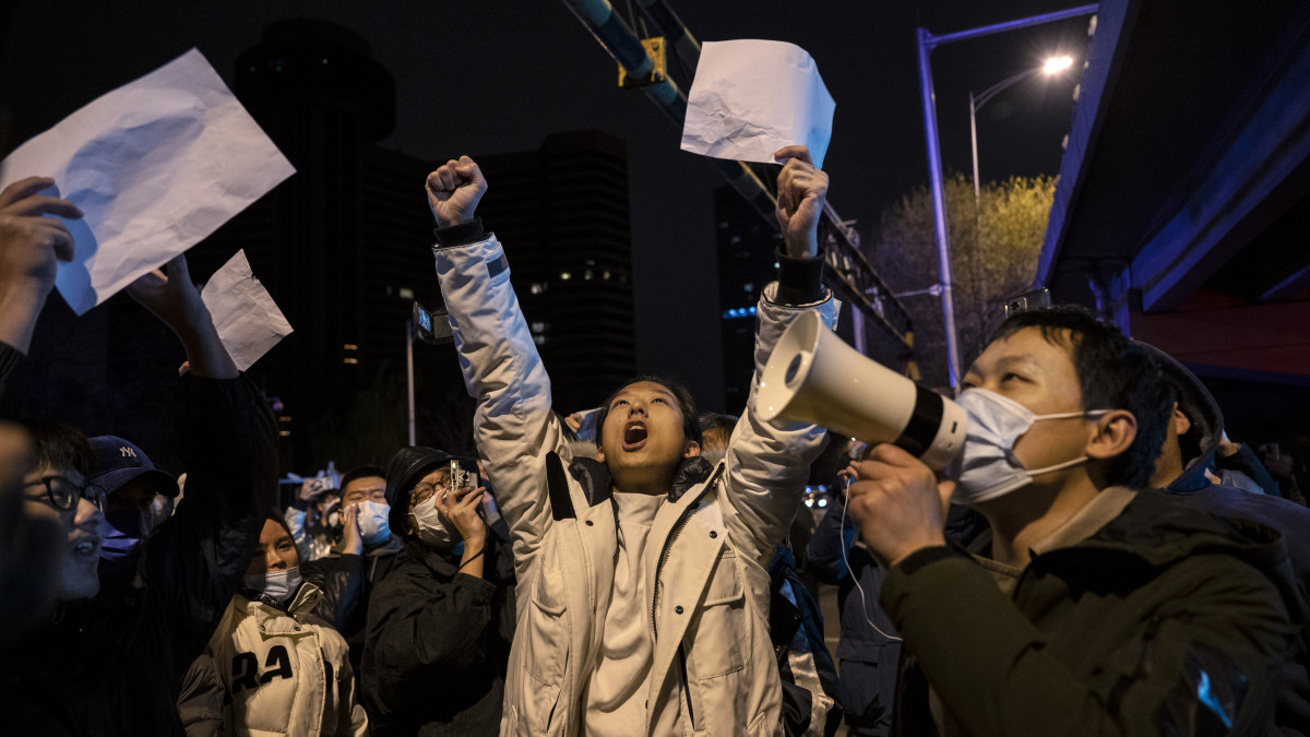 BEIJING, CHINA -NOVEMBER 28: Protesters shout slogans during a protest against Chinas strict zero COVID measures on November 28, 2022 in Beijing, China. Protesters took to the streets in multiple Chinese cities after a deadly apartment fire in Xinjiang province sparked a national outcry as many blamed COVID restrictions for the deaths. (Photo by Kevin Frayer/Getty Images)
