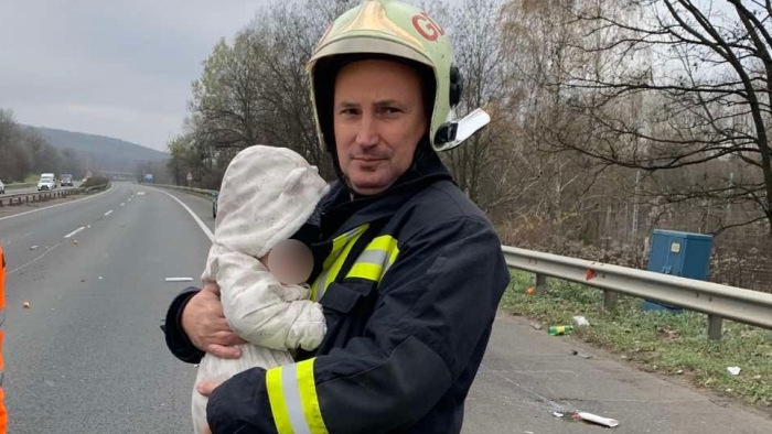 Könnycsalogató fotón melegíti a tűzoltó a balesetet szenvedett csecsemőt
