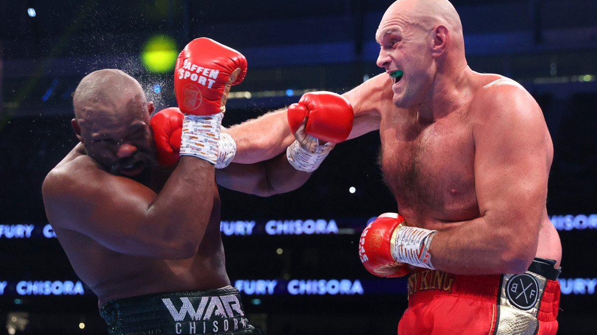 LONDON, ENGLAND - DECEMBER 03: Derek Chisora (L) and Tyson Fury (R) exchange punches during their WBC heavyweight championship fight, at Tottenham Hotspur Stadium on December 03, 2022 in London, England. (Photo by Mikey Williams/Top Rank Inc via Getty Images)