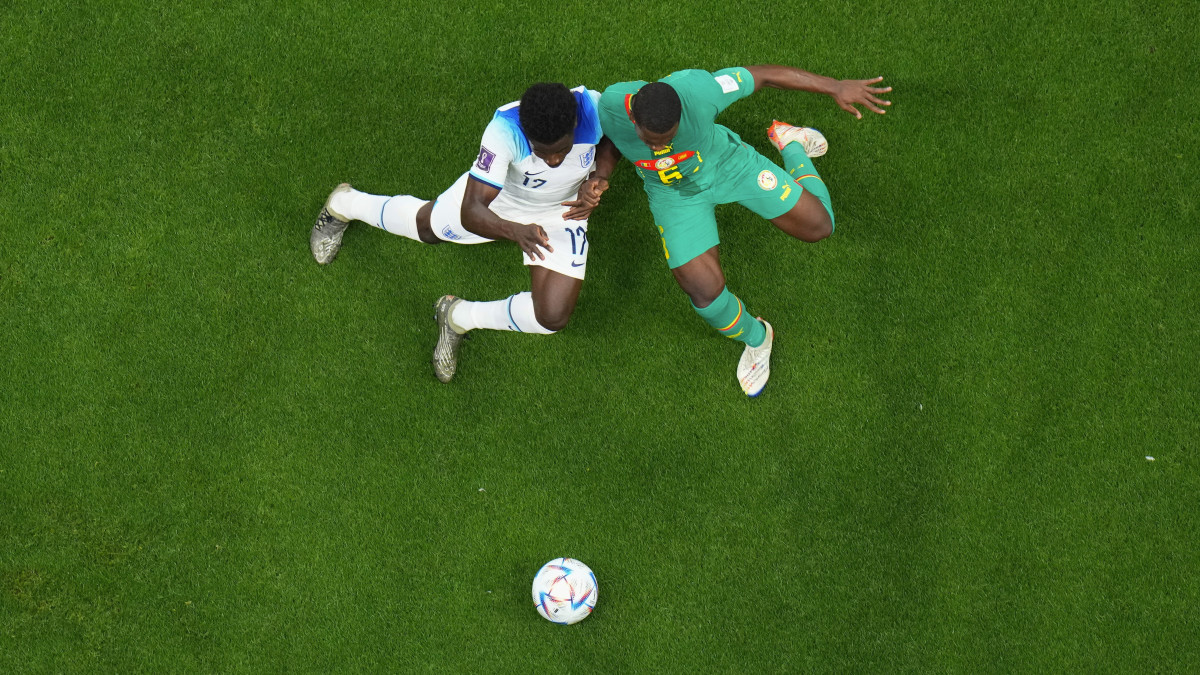 Az angol Bukayo Saka (b) és a szenegáli Nampalys Mend a katari labdarúgó-világbajnokság nyolcaddöntőjében játszott Anglia-Szenegál mérkőzésen az al-hori al-Bajt Stadionban 2022. december 4-én.