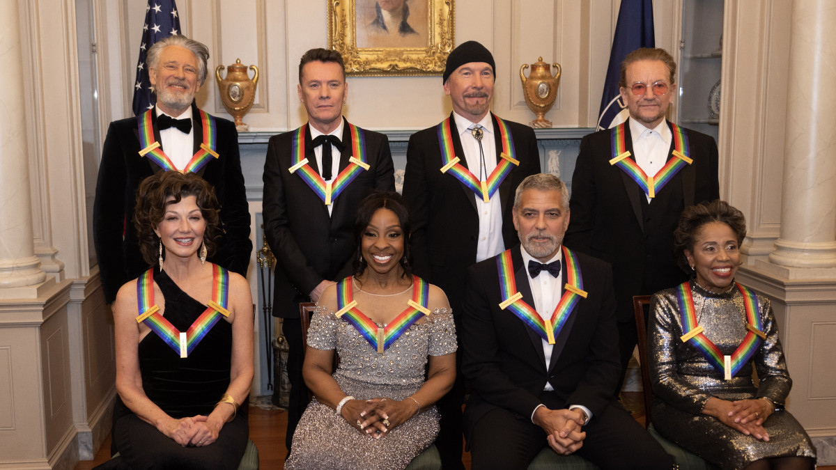 A John F. Kennedy Előadóművészeti Emlékközpont 2022. évi díjazottjainak csoportképe az elismerés 45. átadási ünnepségét megelőző díszvacsorán a washingtoni külügyminisztériumban 2022. december 3-án. Az első sorban (b-j): Amy Grant amerikai énekes-dalszerző, Gladys Knight amerikai gospelénekesnő, George Clooney amerikai filmszínész, rendező és Tania León kubai születésű amerikai zeneszerző, karmester. A hástó sorban (b-j): a U2 ír rockzenekar tagjai: Adam Clayton, Larry Mullen Jr., The Edge és Bono.