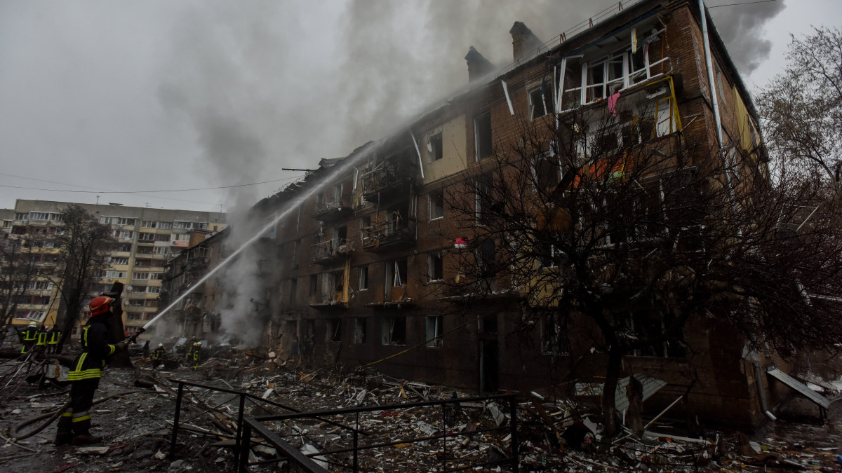 Tűzoltók dolgoznak egy orosz rakétatámadásban megrongálódott lakóépületnél a Kijevtől északra fekvő Vishorodban 2022. november 23-án. Andrij Nyebitov Kijev megyei rendőrfőnök tájékoztatása szerint lakóövezetet és létfontosságú infrastrukturális létesítményeket értek rakétatalálatok a régióban.